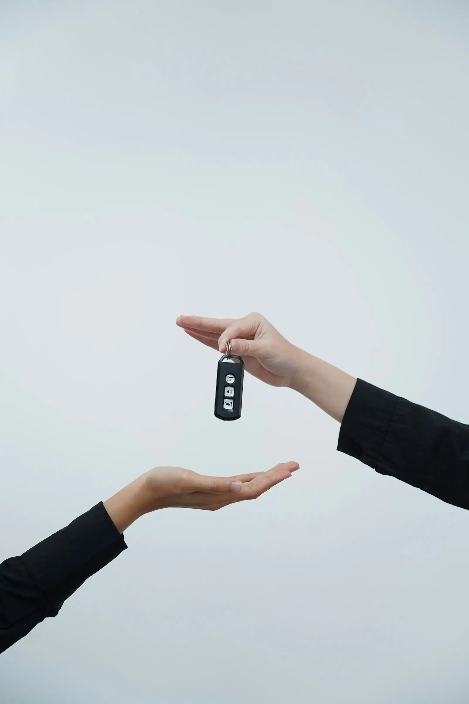 Una mano entrega la llave de un carro a otra persona.