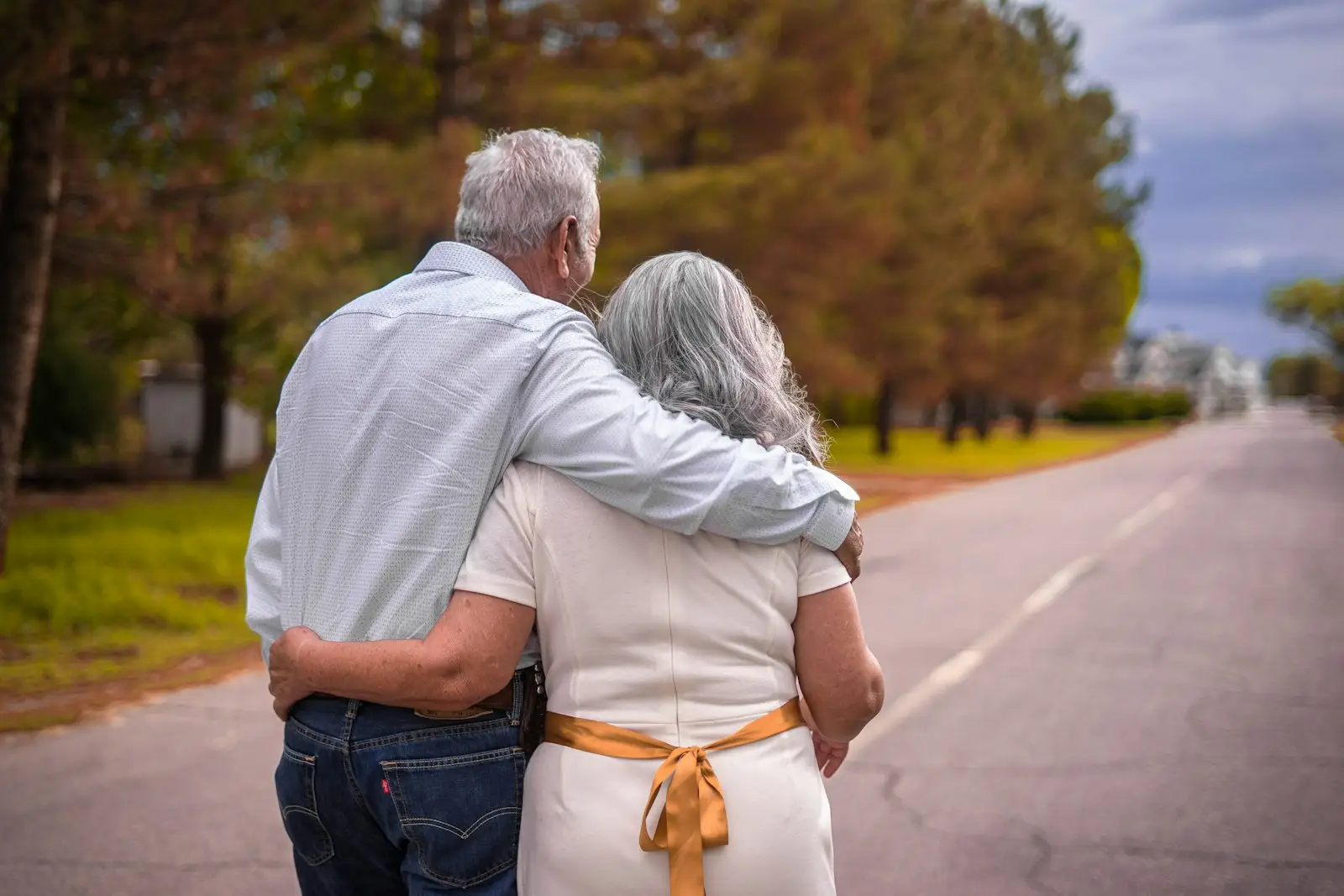 Una pareja de adultos mayores camina por la calle.